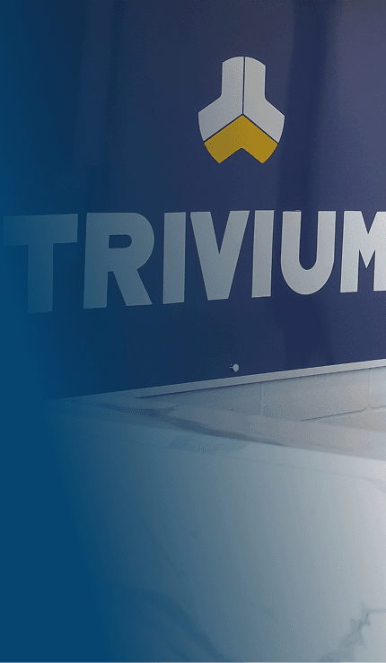 Mesa de atendimento na recepção da Trivium, com o logo da empresa ao fundo.